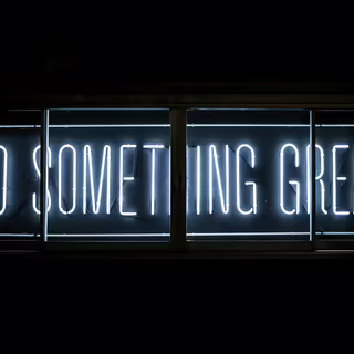 Text “Do Something great” in hellen Neo-Buchstaben auf schwarzer Wand.